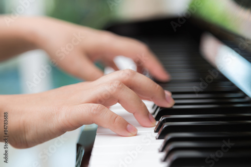 Close up of woman hands playing piano