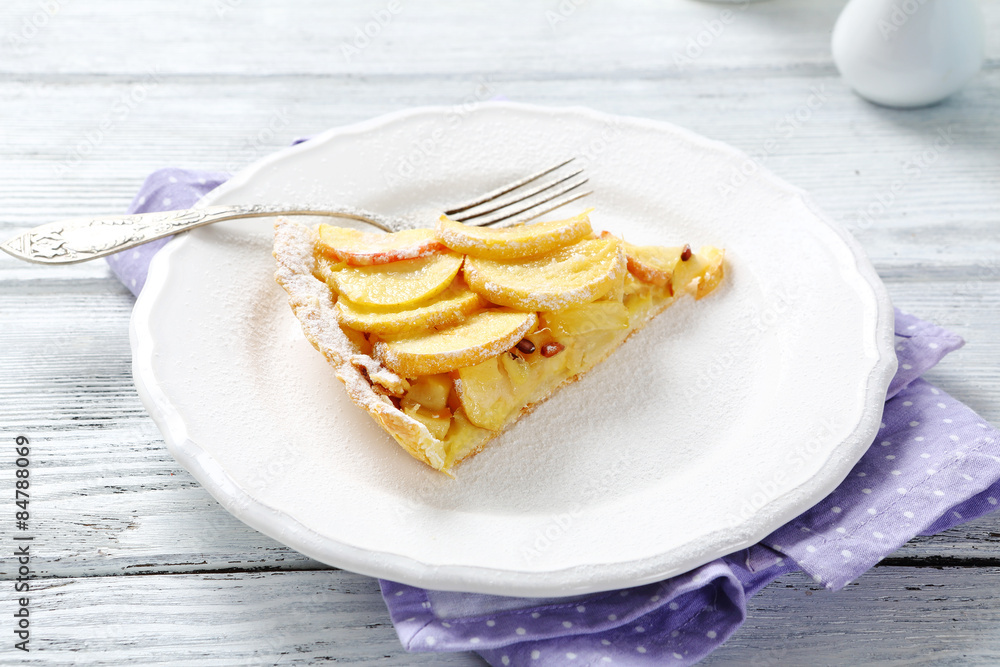 Slice of tart with apples on a plate