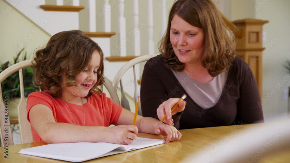 Mother helping daughter with homework Mother helping daughter with homework