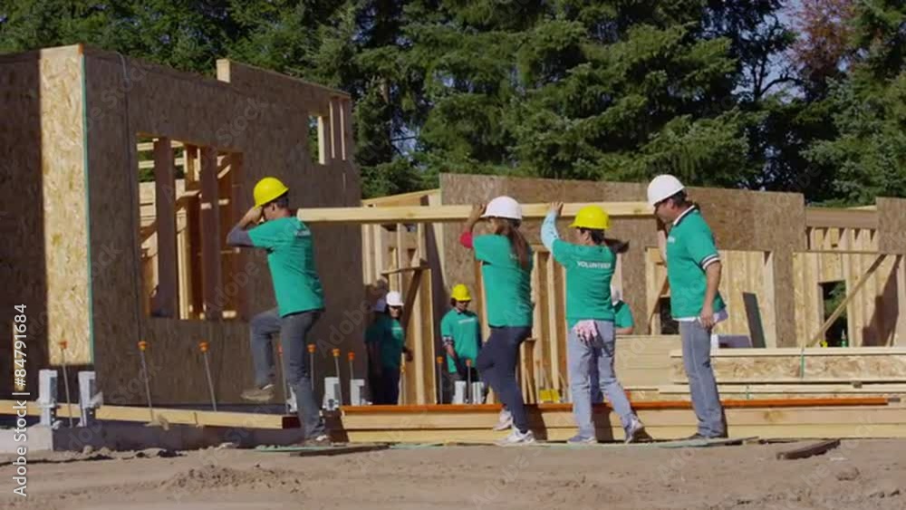 Volunteers working together carrying lumber Volunteers working together carrying lumber