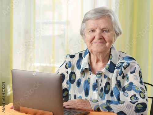 Senior woman with laptop in her room.