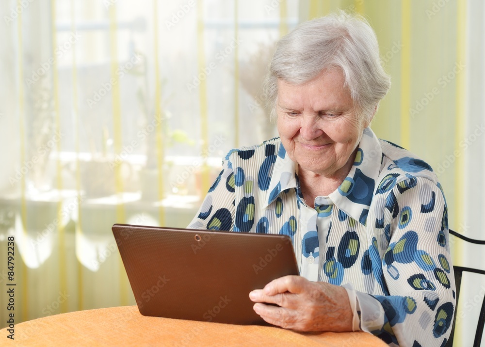 Senior woman with tablet in her room.