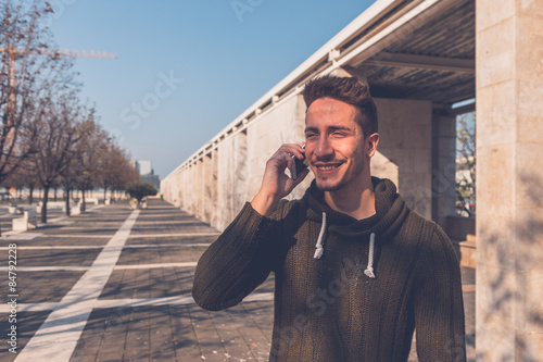 Young handsome man talking on phone