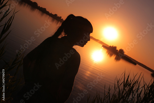 Girl at the lake at sunset