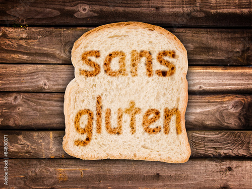 Text sans gluten toasted on a slice of bread, isolated on wood background