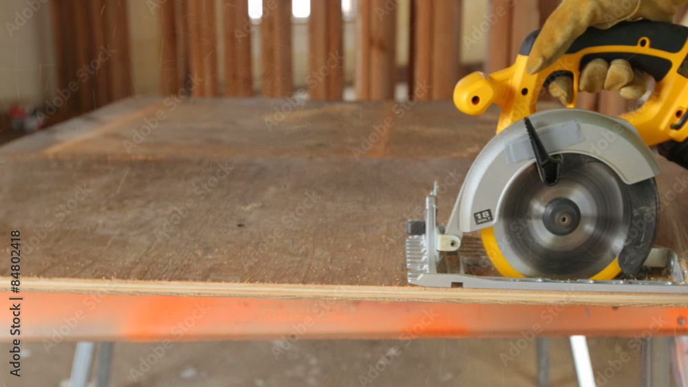 Closeup of construction worker cutting plywood Closeup of construction worker cutting plywood