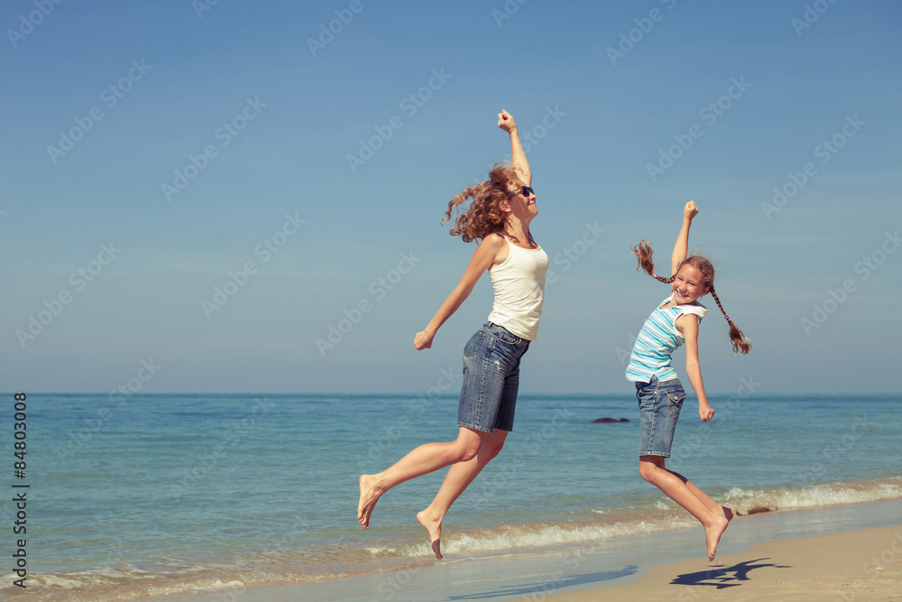 Mother and daughter playing on the beach at the day time. Mother and daughter playing on the beach at the day time.