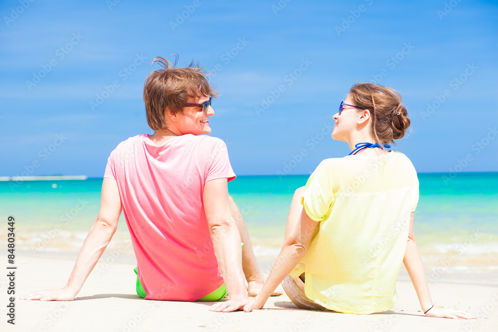 happy young couple sitting on a tropical beach in Barbados happy young couple sitting on a tropical beach in Barbados