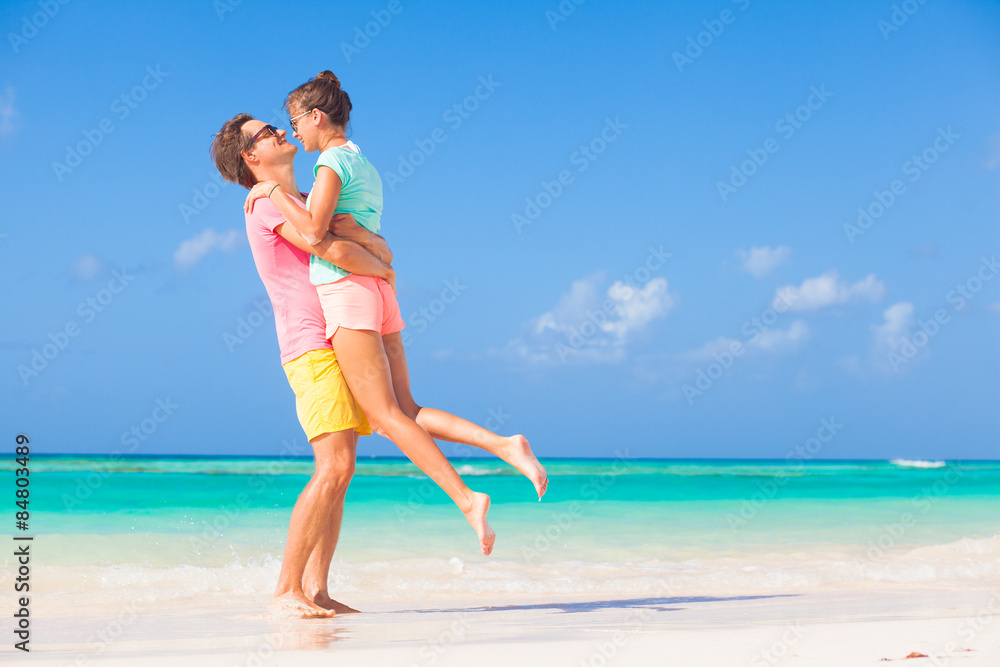 back view of happy romantic young couple hugging on the beach back view of happy romantic young couple hugging on the beach