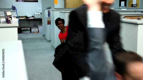 BusiBusinessman pushing co-worker through office on chair