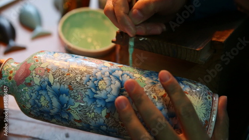 Beijing, China - December 6, 2013: Factory worker paints vase photo