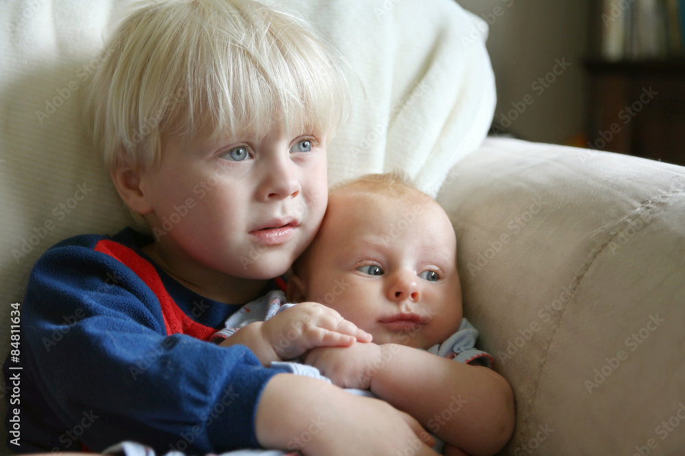 Toddler Brother Holding Baby Sister on Couch Toddler Brother Holding Baby Sister on Couch