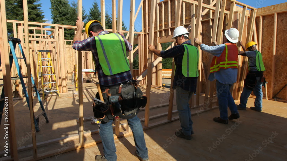 Group of construction workers staning up wall