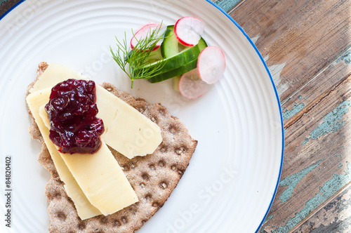 Scandinavian crisp bread topped with cheese and lingonerry jam served with a salad of cucumber, radish and dill.