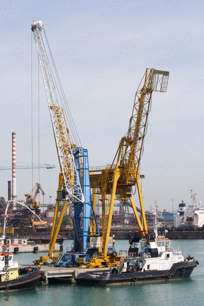 Piombino, Italy -Cranes and moored boats in the Industrial Port of Piombino