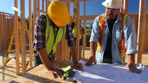 Construction workers looking over plans together