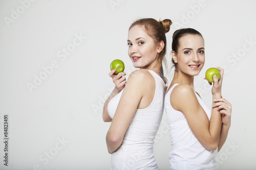 Two young woman with green apples