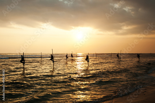 Silhouettes of the traditional stilt fishermen at sunset near Ga