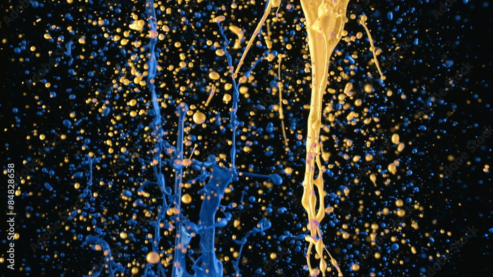Yellow and blue paint splattering in slow motion