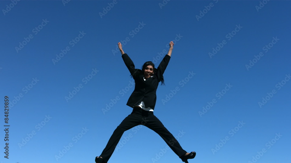 Businesswoman jumping in air doing splits