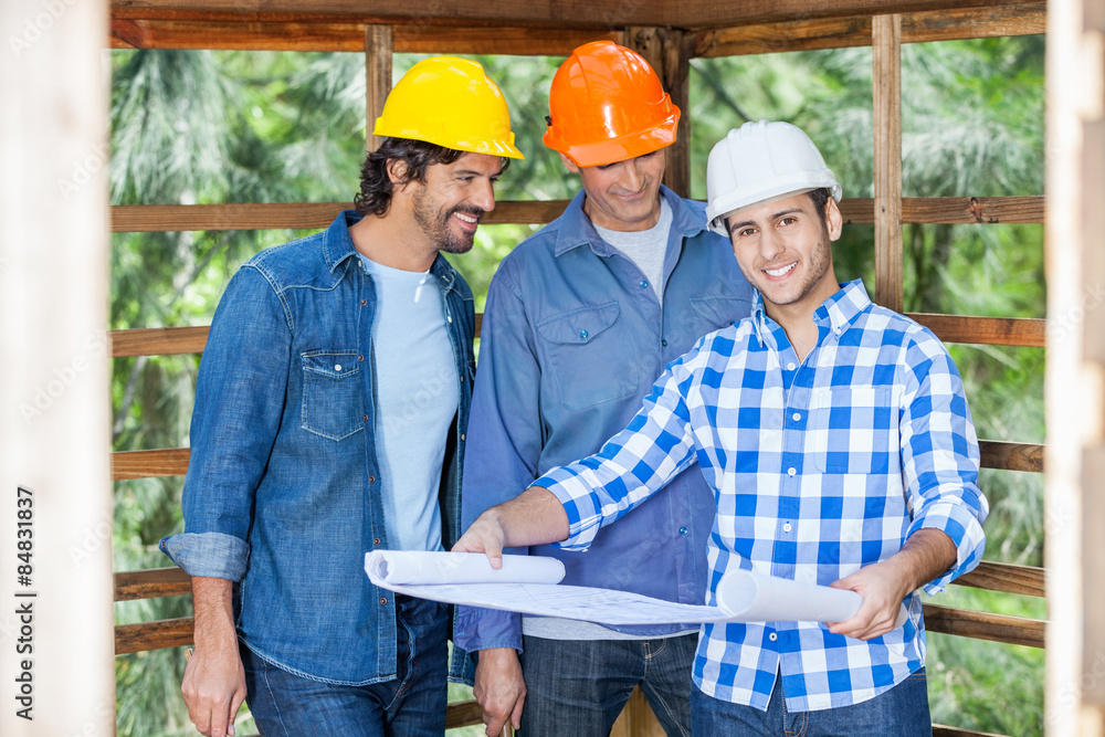 Fototapeta premium Happy Architect With Colleagues Analyzing Blueprint At Site