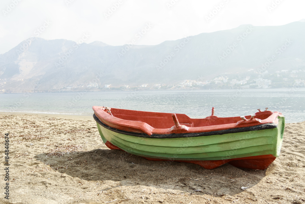 Fototapeta premium Greek fishing open deck motor boat docked on Telendos island sandy coastline
