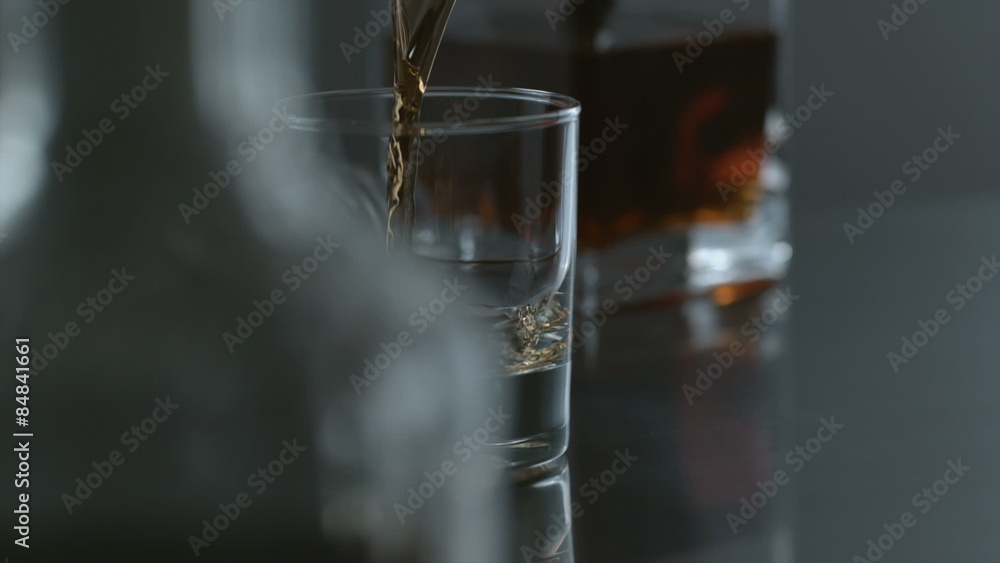 Whisky is poured into glass in slow motion Whisky is poured into glass in slow motion