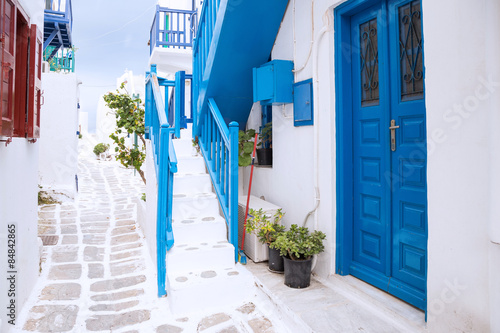 Fototapeta Naklejka Na Ścianę i Meble -  Streetview of Mykonos town with white street, stairs and blue door, Greece