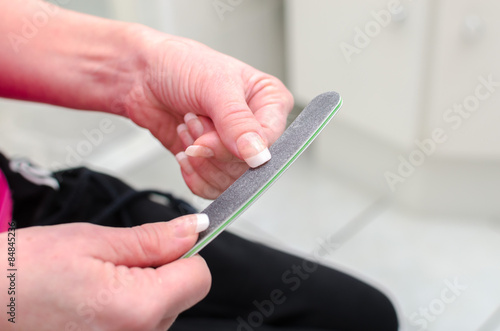 Woman filing her nails