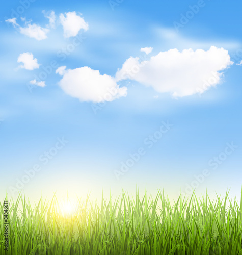 Green grass lawn with clouds and sun on blue sky