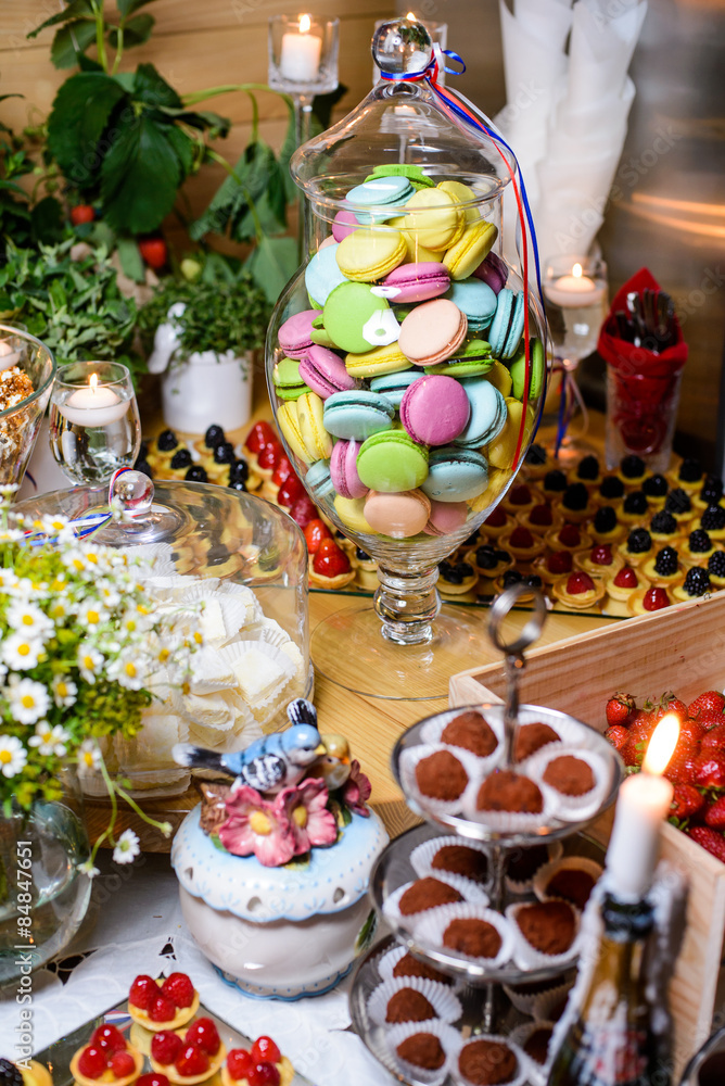 Dessert table at a party with lots of sweets/Macaroon, cake, candy, marshmallows and other sweets on the festive table
