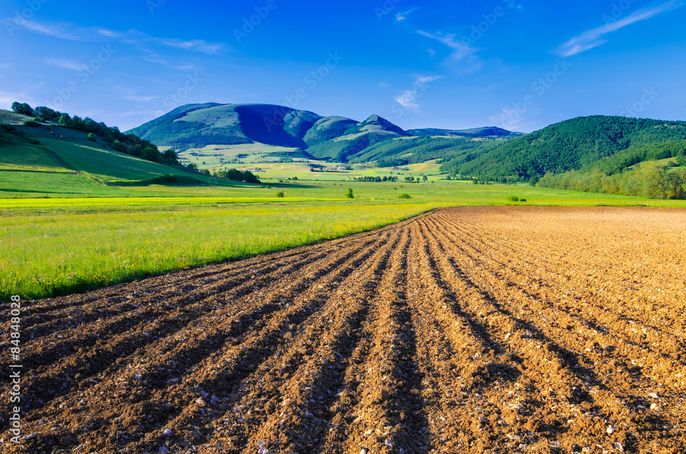 A ploughed field with the Mount Pennino in the background. Photo taken in the Colfiorito plateau, Umbria, Italy