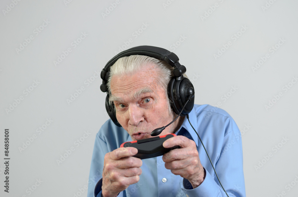 Lustiger Großvater spielt ein Videospiel auf der Konsole Lustiger Großvater spielt ein Videospiel auf der Konsole