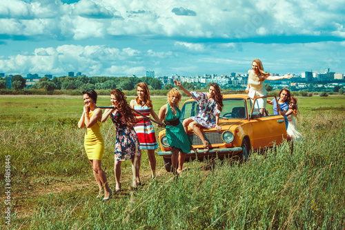 Group of women is pulling a car with the towing cable.