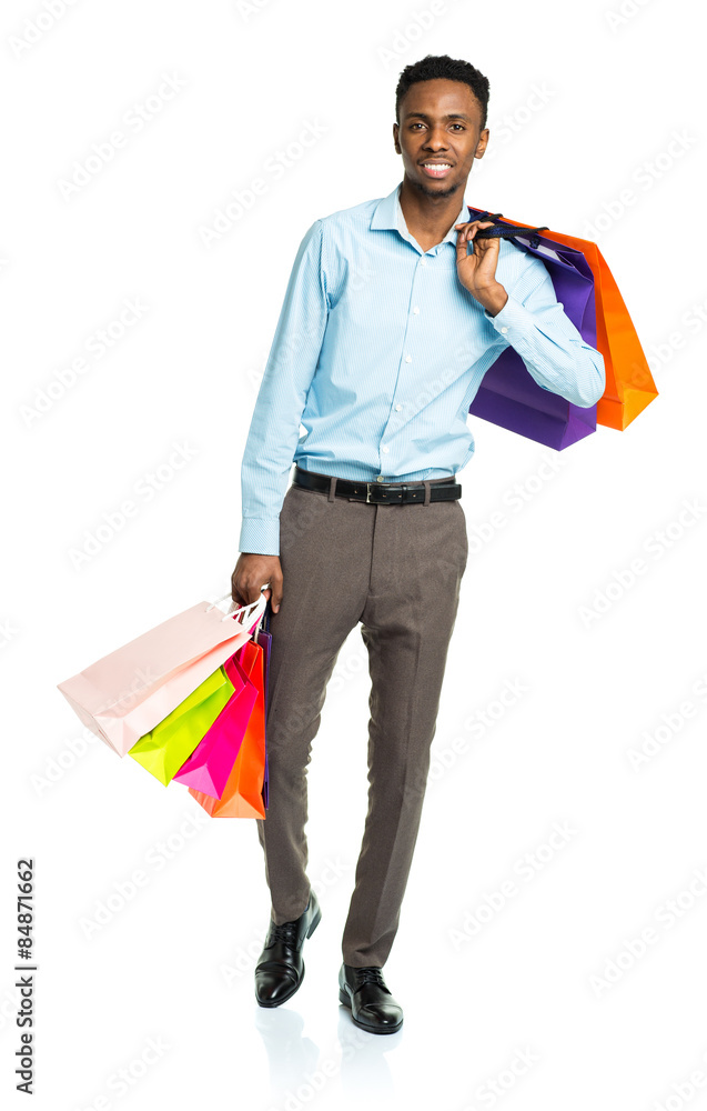 Happy african american man holding shopping bags on white. Holid