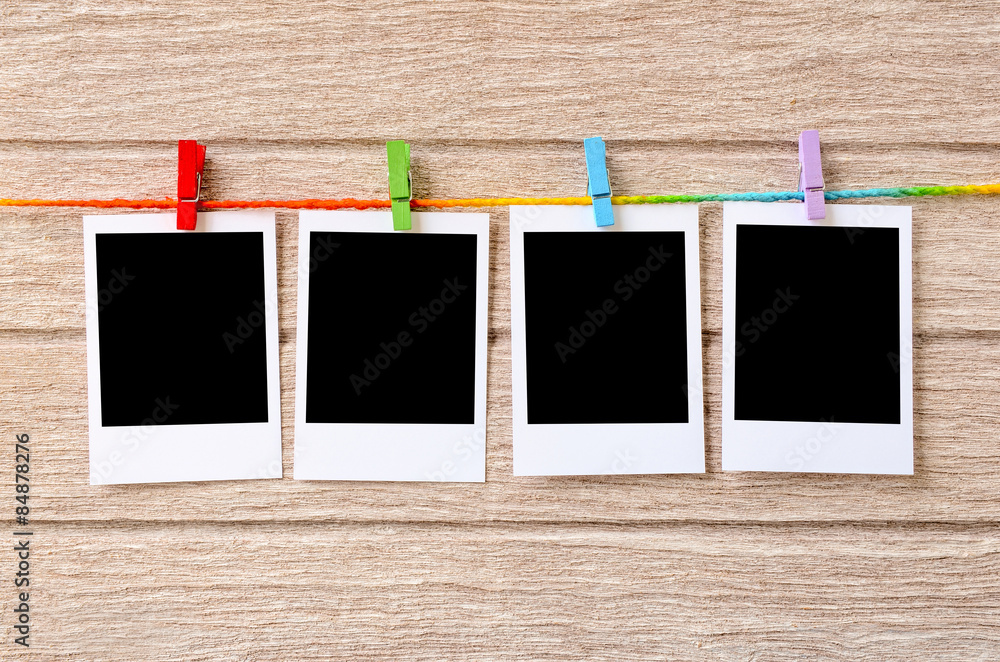 empty black photo frames hanging with clothespins on wooden back empty black photo frames hanging with clothespins on wooden back
