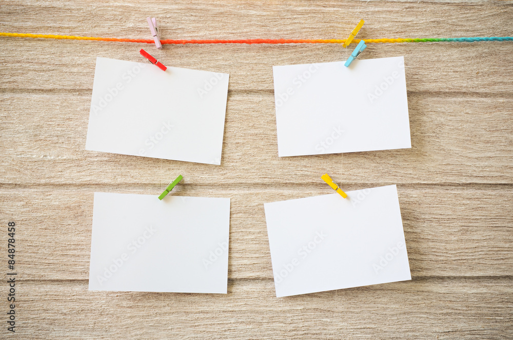empty white photo frames hanging with clothespins on wooden background empty white photo frames hanging with clothespins on wooden background