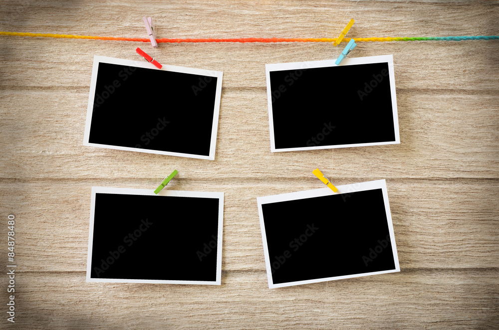 empty black photo frames hanging with clothespins on wooden back empty black photo frames hanging with clothespins on wooden back