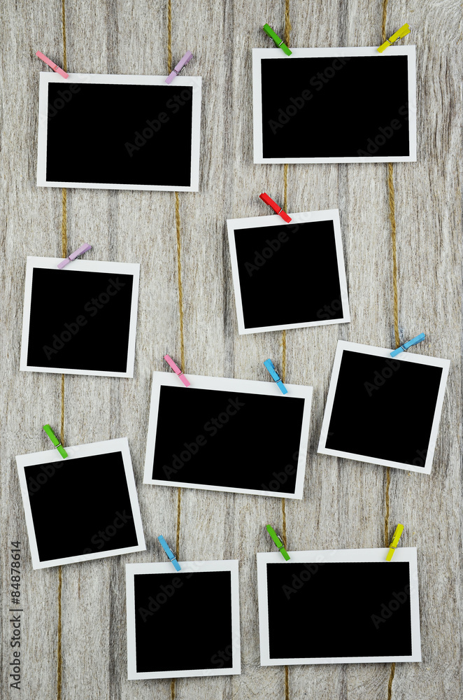 empty black photo frames hanging with clothespins on wooden back empty black photo frames hanging with clothespins on wooden back