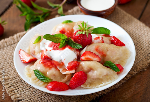 Fresh dumplings with strawberries and sour cream