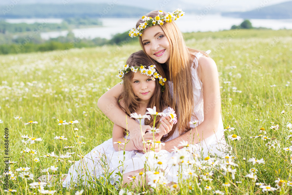 Two child girls at field with mountains view Two child girls at field with mountains view