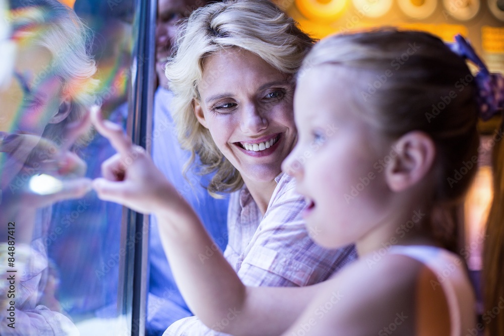 Happy family looking at starfish in a tank Happy family looking at starfish in a tank