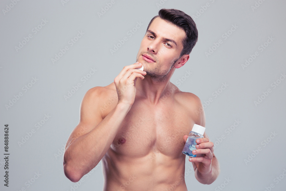 Man applying lotion after shave on face Man applying lotion after shave on face