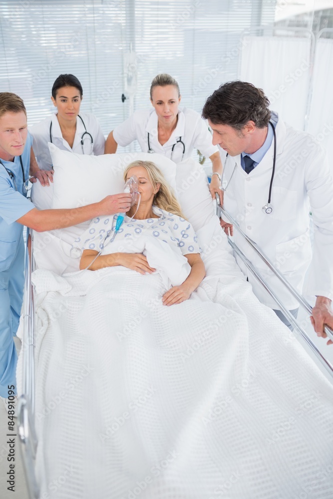Team of doctors carrying patient on stretcher Team of doctors carrying patient on stretcher