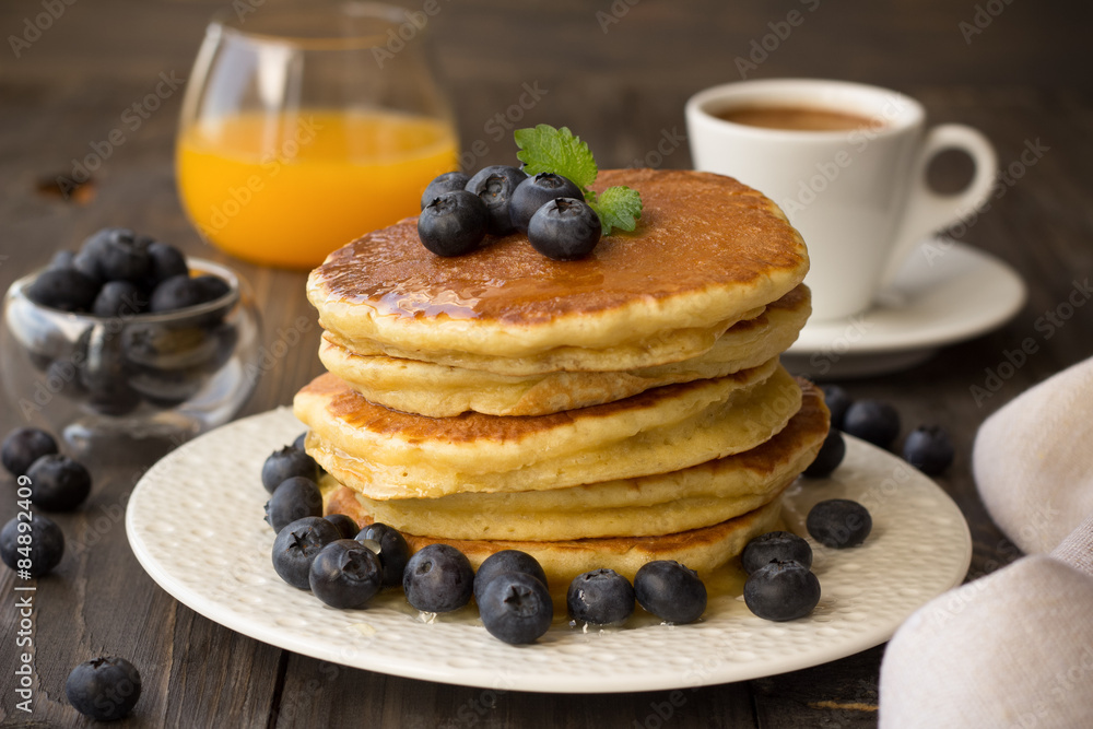 Pancakes with fresh blueberries and honey on wooden table Pancakes with fresh blueberries and honey on wooden table