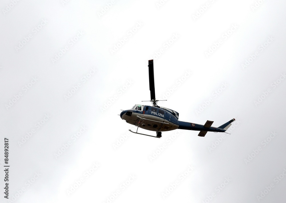 Italian police helicopter flying over the city