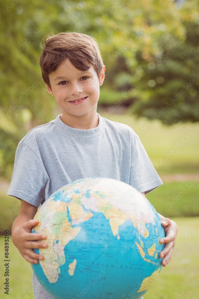Smiling boy holding an earth globe in the park Smiling boy holding an earth globe in the park