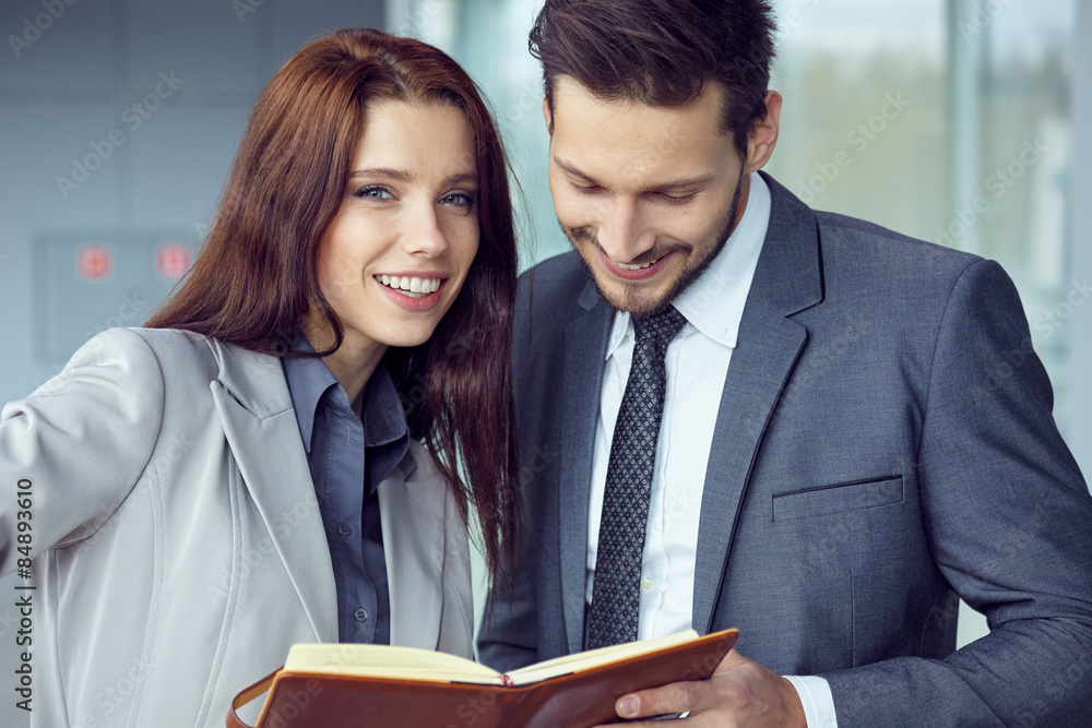 Portrait of a smiling young business couple standing with arms c Portrait of a smiling young business couple standing with arms c