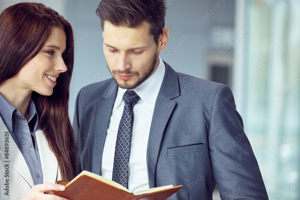 Portrait of a smiling young business couple standing with arms c Portrait of a smiling young business couple standing with arms c