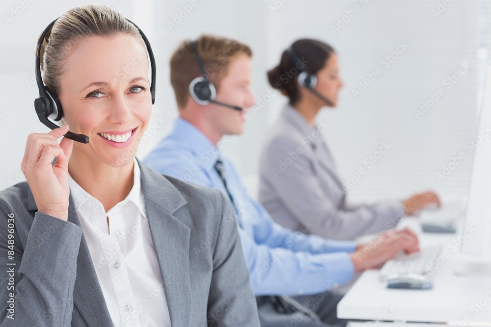Business team working on computers and wearing headsets Business team working on computers and wearing headsets